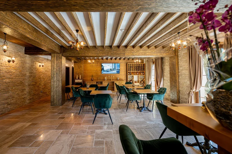 Salonul restaurantului cu grinzi din lemn și candelabre