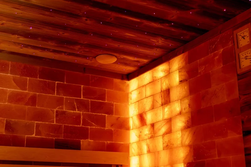 Sauna cu pereți din sare de Himalaya, luminată în portocaliu